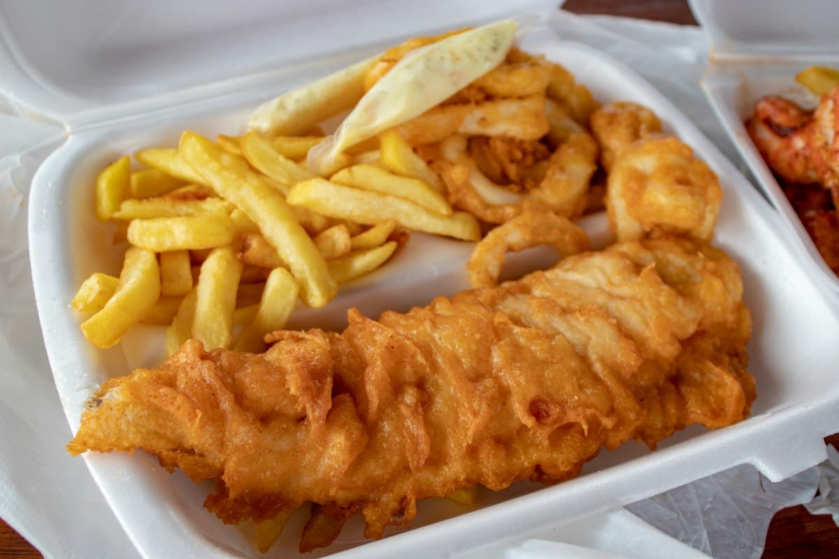 Battered cod with thick-cut chips in a takeaway box